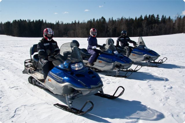 Три снегохода Arctic Cat Bearcat на заснеженном поле